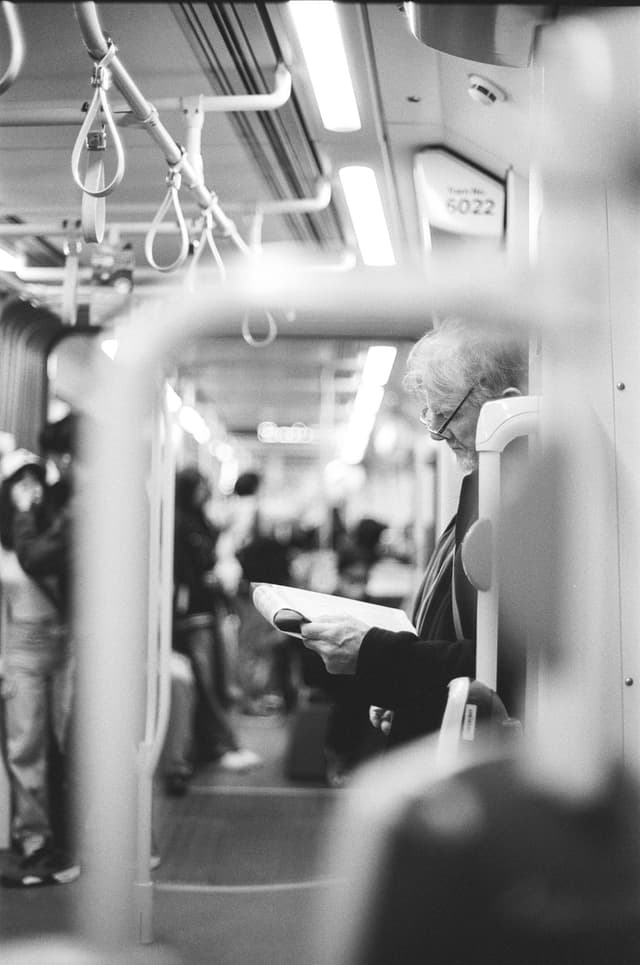 A man reading news on tram